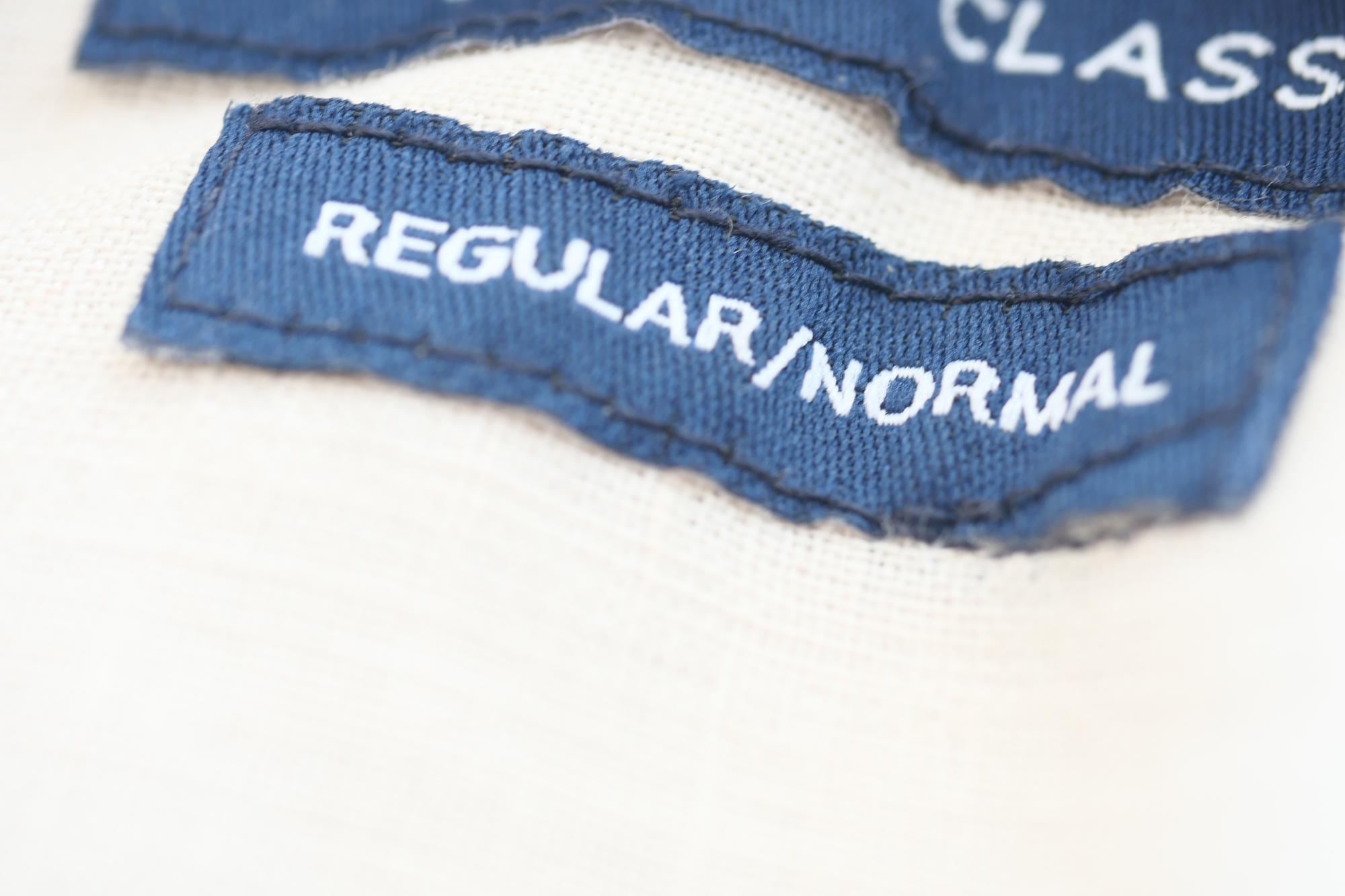 Embroidered label sewn into garment hem